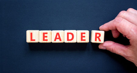 Leadership and leader symbol. Concept word Leader on beautiful wooden blocks. Beautiful black background. Businessman's hand. Business leader and leadership concept. Copy space.の写真素材