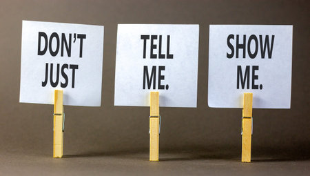 Tell or show symbol. Concept words Do not just tell me, show me on beautiful white papers on wooden clothespins. Beautiful gray background. Business tell or show concept. Copy space.の写真素材