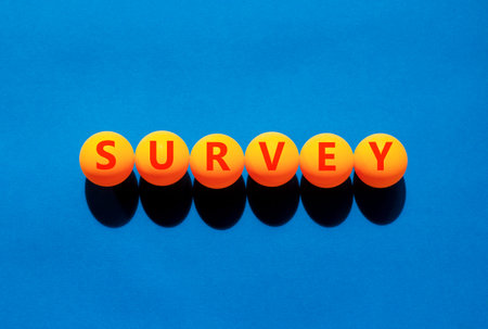 Survey word symbol. Concept word Survey on beautiful orange table tennis ping pong balls. Beautiful blue background. Business psychological medical survey word concept. Copy space.の写真素材
