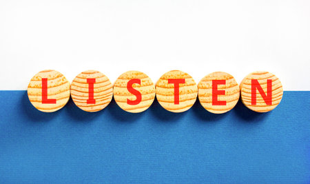 Listen symbol. Concept Listen word on beautiful wooden circles. Beautiful blue and white background. Business education listen concept. Copy space.の写真素材