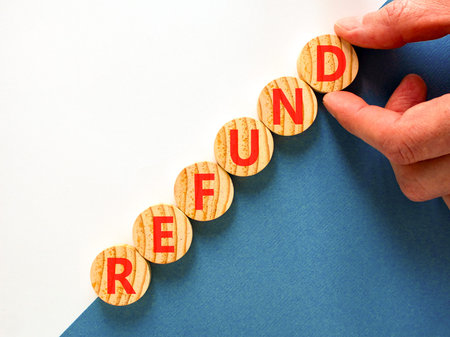 Refund word symbol. Concept word Refund on beautiful wooden circles. Beautiful blue and white background. Businessman's hand. Business word refund concept. Copy space.の写真素材