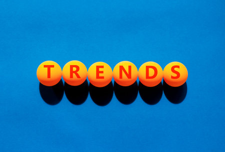 Trends trend word symbol. Concept word Trends on beautiful orange table tennis ping pong balls....