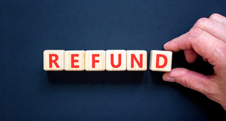 Refund word symbol. Concept word Refund on beautiful wooden blocks. Beautiful black background. Businessman's hand. Business word refund concept. Copy space.の写真素材