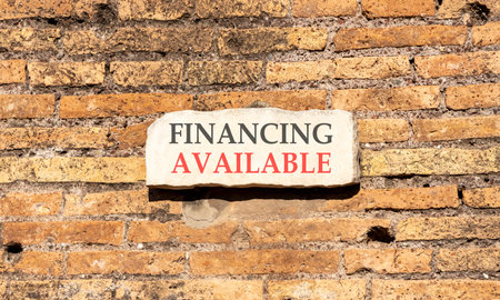 Financing available symbol. Concept words Financing available on beautiful big white sign plate. Beautiful old brown brick wall background. Business available financing concept. Copy space.の写真素材