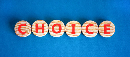 Choice symbol. Concept word Choice on beautiful wooden circles. Beautiful blue background. Business choice concept. Copy space.の写真素材
