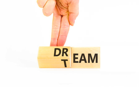 Dream team symbol. Concept words Dream team on beautiful wooden cubes. Beautiful white background. Businessman's hand. Business and dream team concept. Copy space.の写真素材
