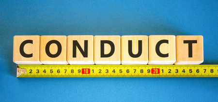 Conduct symbol. Concept word Conduct on beautiful wooden blocks. Beautiful blue background. Beautiful yellow ruler. Business conduct concept. Copy space.の写真素材