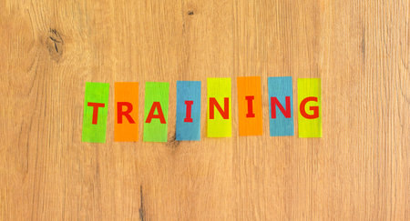 Training word symbol. Concept word Training on beautiful colored papers. Beautiful wooden background. Business support help training word concept. Copy space.の写真素材
