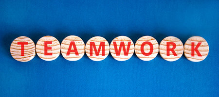 Teamwork word symbol. Concept word Teamwork on beautiful wooden circles. Beautiful blue background. Business support help teamwork word concept. Copy space.の写真素材