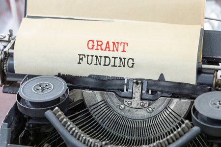 Grant funding symbol. Concept words Grant funding typed on beautiful old retro typewriter. Beautiful...