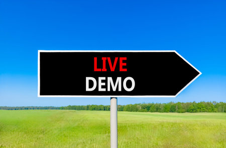 Live demo symbol. Concept words Live demo on beautiful black road sign. Beautiful blue sky green...