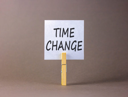 Time change symbol. Concept word Time change on beautiful white paper. Beautiful wooden clothespin....