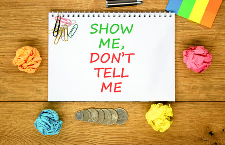 Tell or show symbol. Concept words Show me, do not tell me on beautiful white note. Beautiful wooden background. Colored paper. Black pen. Business tell or show concept. Copy space.の写真素材