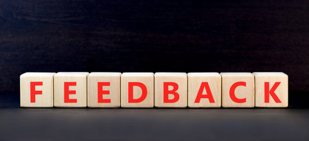 Feedback word symbol. Concept word Feedback on beautiful wooden blocks. Beautiful black background....