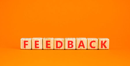 Feedback word symbol. Concept word Feedback on beautiful wooden blocks. Beautiful orange background. Business support help feedback word concept. Copy space.の写真素材