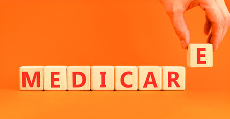 Medicare word symbol. Concept word Medicare on beautiful wooden blocks. Beautiful orange background....