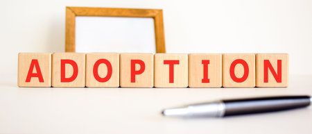 Adoption word symbol. Concept word Adoption on beautiful wooden blocks. Beautiful white background....