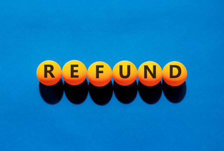 Refund word symbol. Concept word Refund on beautiful orange table tennis ping pong balls. Beautiful...