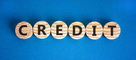 Credit symbol. Concept word Credit on beautiful wooden circles. Beautiful blue background. Business...