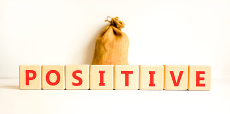 Positive word symbol. Concept word Positive on beautiful wooden blocks. Beautiful white background. Beautiful canvas bag. Business support help positive word concept. Copy space.の写真素材