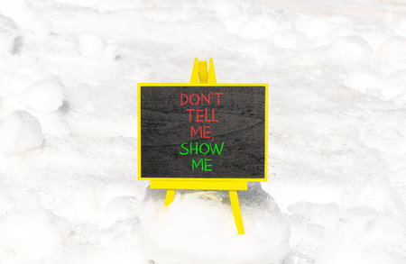 Tell or show symbol. Concept words Do not tell me, show me on beautiful black blackboard. Beautiful...