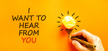 I want to hear from you symbol. Concept words I want to hear from you on beautiful orange paper. Beautiful orange background. Light bulb. Business support I want to hear from you concept. Copy space.の写真素材