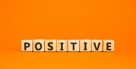 Positive word symbol. Concept word Positive on beautiful wooden blocks. Beautiful orange background. Business support help positive word concept. Copy space.の写真素材