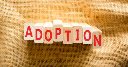 Adoption word symbol. Concept word Adoption on beautiful wooden blocks. Beautiful canvas background....