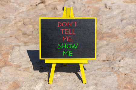 Tell or show symbol. Concept words Do not tell me, show me on beautiful black blackboard. Beautiful...