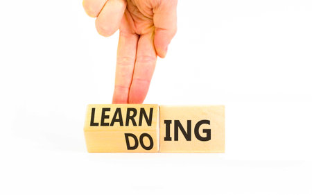 Doing or learning symbol. Concept words Doing to Learning on beautiful wooden cubes. Beautiful white...