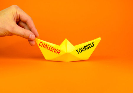 Challenge yourself words symbol. Concept words Challenge yourself on beautiful yellow paper boat....