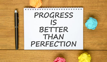 Progress or perfection words symbol. Concept words Progress is better than perfection on beautiful white note. Beautiful wooden background. Business progress or perfection concept. Copy space.の写真素材