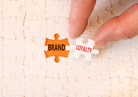 Brand loyalty words symbol. Concept words Brand loyalty on beautiful white puzzles. Beautiful orange...