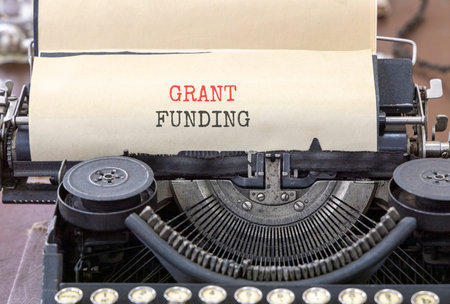 Grant funding symbol. Concept words Grant funding typed on beautiful old retro typewriter. Beautiful...