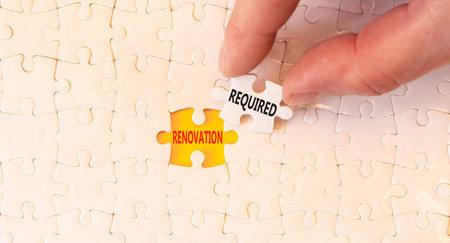 Renovation required words symbol. Concept words Renovation required on beautiful white puzzles....