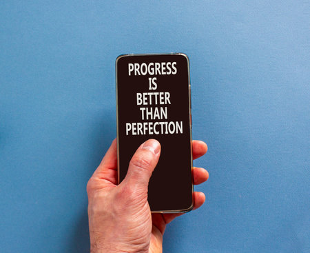 Progress or perfection words symbol. Concept words Progress is better than perfection on beautiful phone screen. Beautiful blue background. Business progress or perfection concept. Copy space.