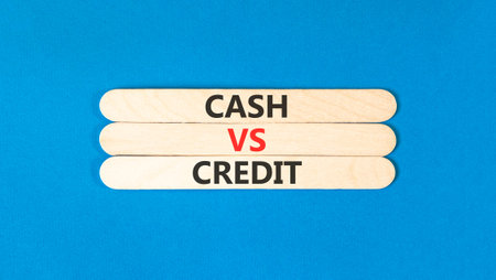 Cash vs credit words symbol. Concept words Cash vs credit on beautiful wooden sticks. Beautiful blue background. Business and cash vs credit concept. Copy space.