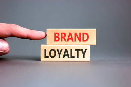 Brand loyalty words symbol. Concept words Brand loyalty on beautiful wooden blocks. Beautiful grey background. Businessman hand. Business and Brand loyalty words concept. Copy space.