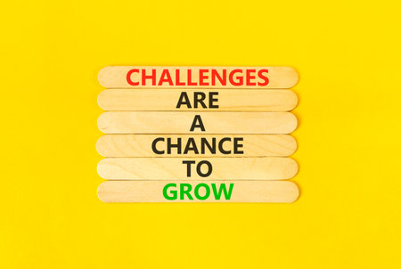 Challenge word symbol. Concept words Challenges are a chance to grow on beautiful wooden sticks. Beautiful yellow paper background. Business challenges are a chance to grow concept. Copy space.