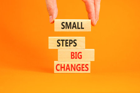 Small steps big changes words symbol. Concept words Small steps big changes on beautiful wooden blocks. Beautiful orange background. Business motivational small steps big changes concept. Copy space.