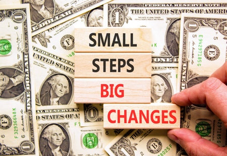 Small steps big changes symbol. Concept words Small steps big changes on beautiful wooden blocks. Beautiful dollar bills background. Business motivational small steps big changes concept. Copy space.
