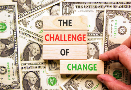 The challenge of change words symbol. Concept words The challenge of change on beautiful wooden blocks. Beautiful dollar bills background. Business the challenge of change concept. Copy space.