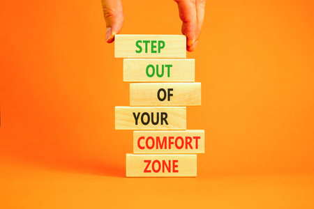Leave comfort zone symbol. Concept words Step out of your comfort zone on beautiful wooden stick. Beautiful orange background. Business psychological step out your comfort zone concept. Copy space.