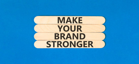 Make your brand stronger words symbol. Concept words Make your brand stronger on beautiful wooden sticks. Beautiful blue background. Business make your brand stronger concept. Copy space.