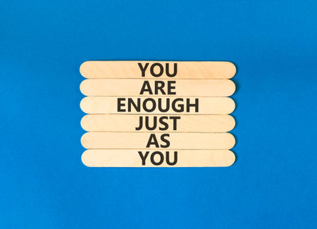 You are enough symbol. Concept words You are enough just as you on beautiful wooden sticks. Beautiful blue background. Business motivational and you are enough just as you concept. Copy space.
