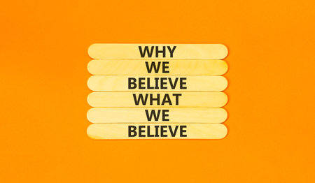 Why or what we believe words symbol. Concept words Why we believe what we believe on beautiful wooden sticks. Beautiful orange background. Business why or what we believe concept. Copy space.