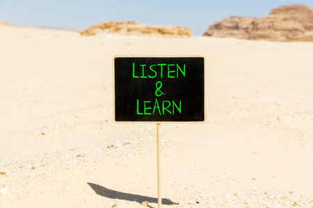 Listen and learn words symbol. Concept words Listen and learn on beautiful blackboard. Beautiful Sinai desert sand background. Business listen and learn support concept. Copy space.