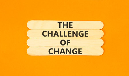 The challenge of change words symbol. Concept words The challenge of change on beautiful wooden sticks. Beautiful orange background. Business the challenge of change concept. Copy space.