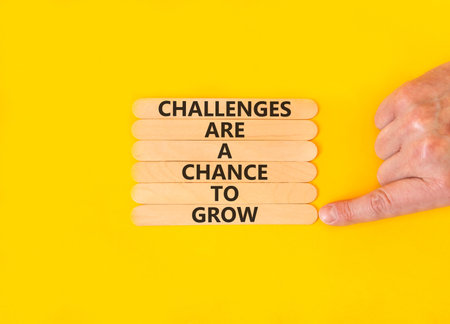 Challenge word symbol. Concept words Challenges are a chance to grow on beautiful wooden sticks. Beautiful yellow paper background. Business challenges are a chance to grow concept. Copy space.