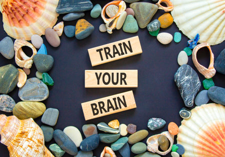 Train your brain words symbol. Concept words Train your brain on beautiful wooden blocks. Beautiful black background. Sea stones sea shells. Business motivational train your brain concept. Copy space